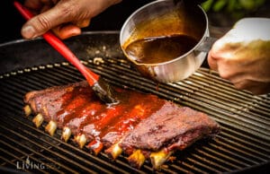 Kugelsmoker – verwandle deinen Holzkohlegrill in einen Smoker Ribs mit BBQ Sauce einpinseln